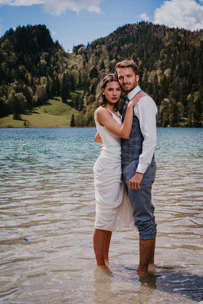 Das Brautpaar barfuß im Bergsee in vertrauter Umarmung